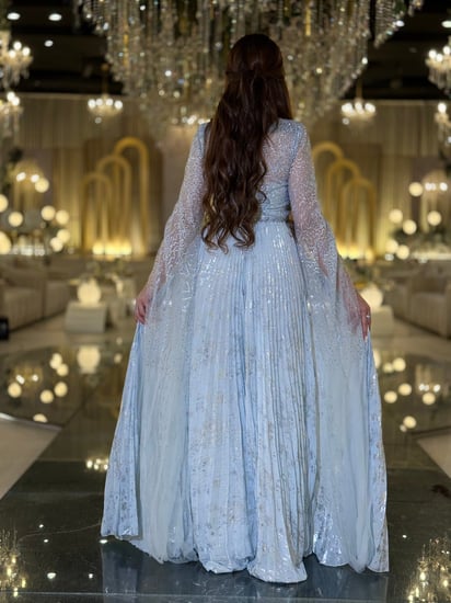 فستان سهرة أزرق لامع بأكمام شفافة قصّة تنساب برقي لتبرز جمالك