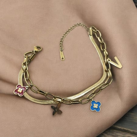 سوار ذهبي مزين بتعليقات زهور ملونة وحرف V بتصميم أنيق