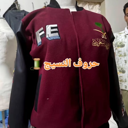 جاكيت خريجات قطن مطرز وأكمام جلد أنثوية.