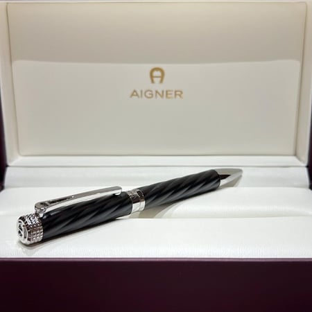 قلم AIGNER الفاخر باللون الأسود والمعدن الفضي مع تصميم حلزوني أنيق