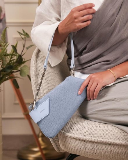 شنطة نسائية متوسطة الحجم بلون أزرق.