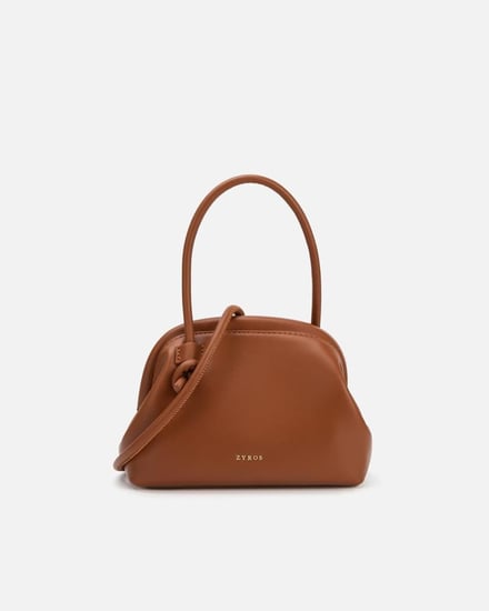 شنطة نسائية كقطعة فنية من الجلد بلون بني