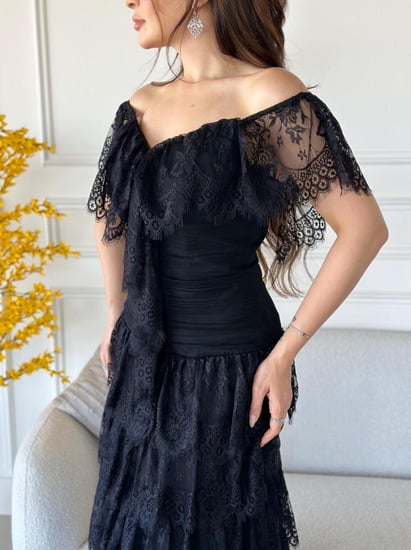 فستان طويل اسود قماش دانتيل ومزين بطبقات واكتاف مكشوفة