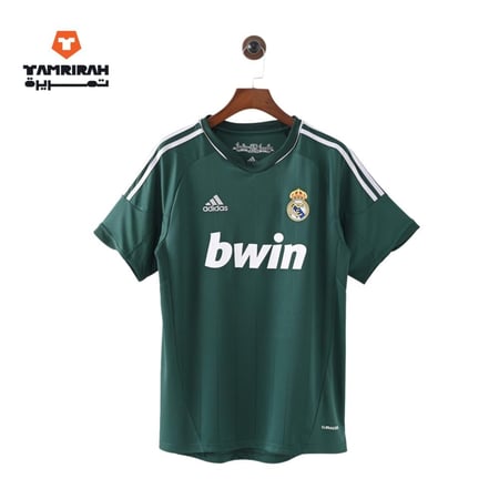 تيشيرت ريال مدريد الأخضر معلق على علاقة ملابس