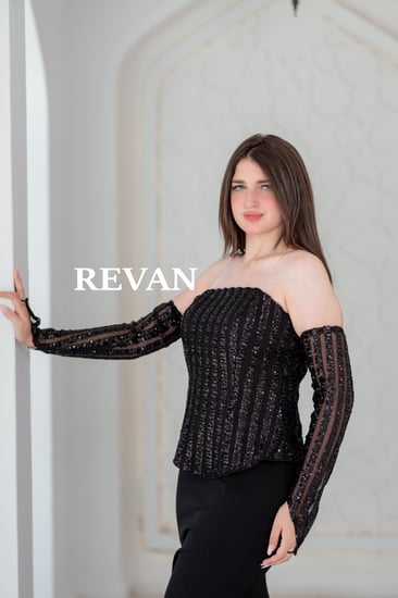 فستان أسود راقٍ بتفاصيل ترتر وأكمام شفافة