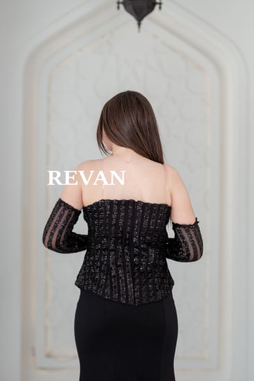 فستان أسود راقٍ بتفاصيل ترتر وأكمام شفافة