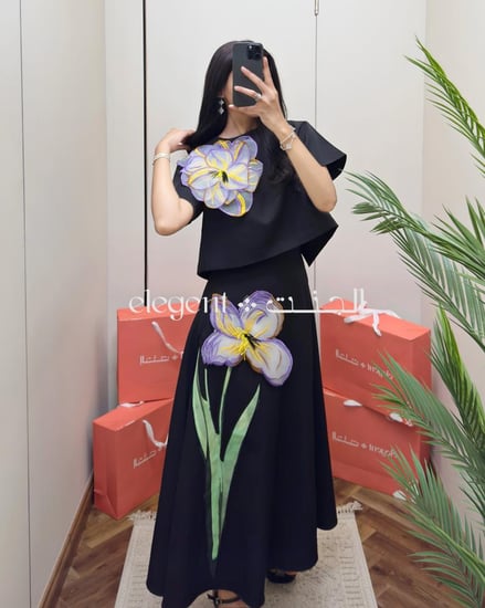 تيور أنيق أسود مزين بوردة بنفسجية على الكتف والتنورة من الجنت