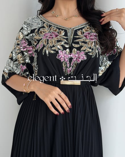 فستان أسود أنيق بتطريز شك ملون وكسرات من الأسفل لإطلالة فخمة