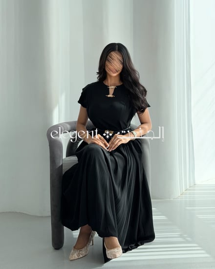 فستان أسود بكسرات انسيابية وقصة أنثوية