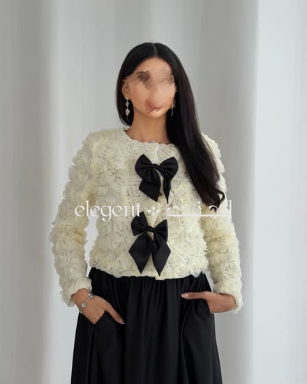 تفاصيل الفيونكات السوداء على الجاكيت الوردي الأبيض – صورة مقربة