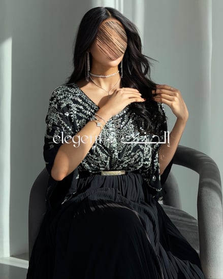 فستان أسود فخم بتطريز شك كامل وكسرات من الأسفل لإطلالة راقية
