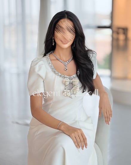 فستان أبيض ناعم بتفصيل أنيق يبرز القوام