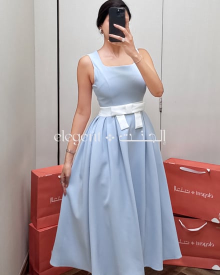 تفاصيل خصر الفستان الأزرق مع فيونكة بيضاء