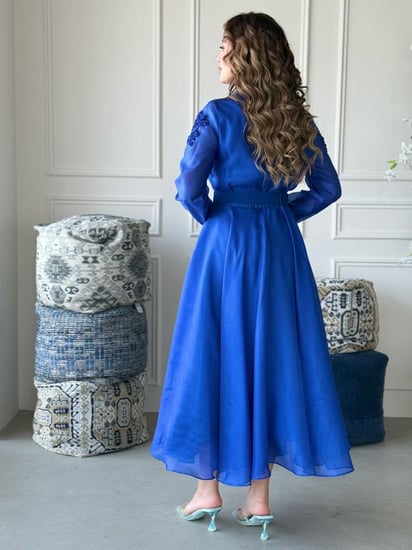 فستان بتصميم واسع وانسيابي مع حزام خصر يُبرز القوام