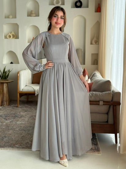 فستان بأكمام شفافة وتفاصيل خفيفة تعطيه إحساس ملكي