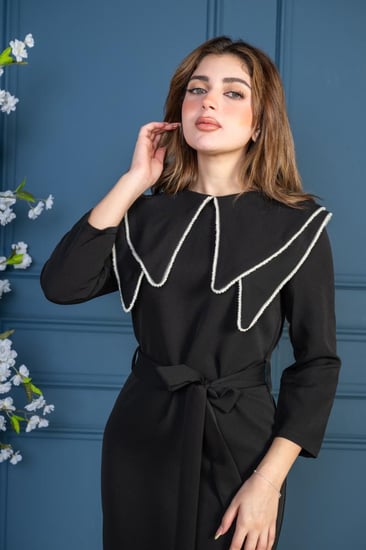 فستان بتصميم فريد مزين بخطوط بيضاء ناعمة على الأطراف