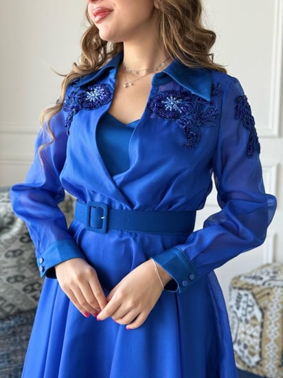 فستان بتصميم واسع وانسيابي مع حزام خصر يُبرز القوام