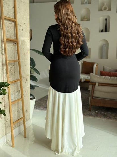 فستان أسود بأكمام مميزة وتفاصيل كشكش بيضاء أنيقة