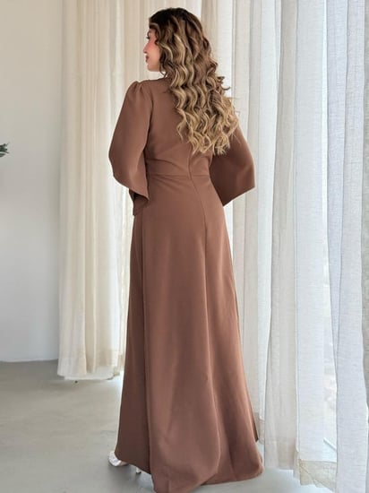 فستان بتصميم فاخر بلمسات ملكية، بأكمام واسعة وقصة أنيقة