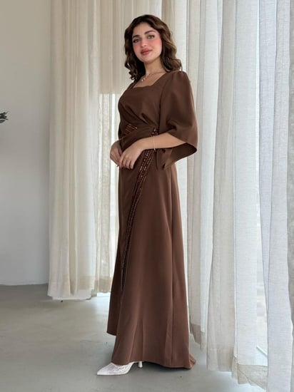 فستان بتصميم فاخر بلمسات ملكية، بأكمام واسعة وقصة أنيقة