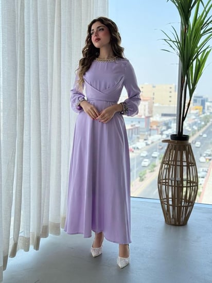 فستان بتفاصيل براقة على الياقة والأكمام وتصميم يلف الخصر بانسيابية