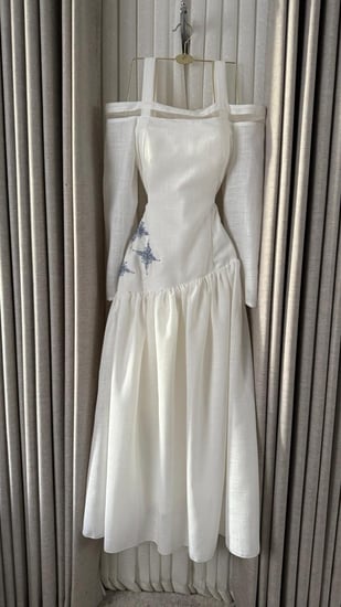 فستان أبيض أنيق بأكمام طويلة وتطريز فضي جانبي