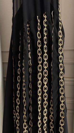فستان سهرة أسود بتفاصيل سلاسل ذهبية