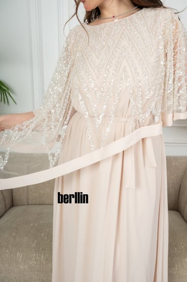 فستان سهره طويل بحافة واسعة واكمام كيب لون بيج