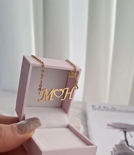 عقد يجمع-حرفين في بريق الذهب عيار 21.