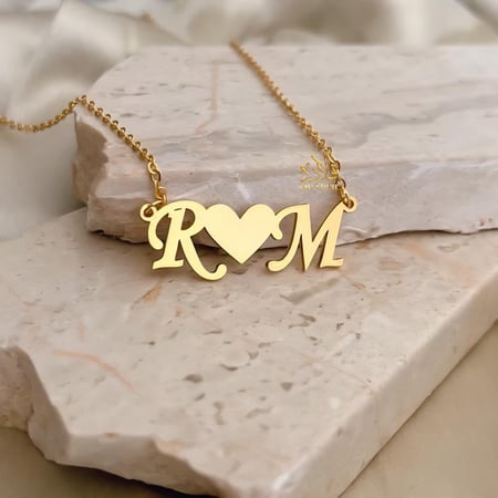 عقد يجمع-حرفين في بريق الذهب عيار 21.