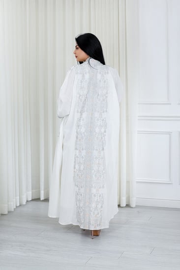 جلابية قماش بطول يصل للكاحل مكونة من قطعة سادة وقطعة مزينة بالترتر اللامع على أطراف الأكمام وعلى طول الجلابية الخارجي ومنتصف الظهر