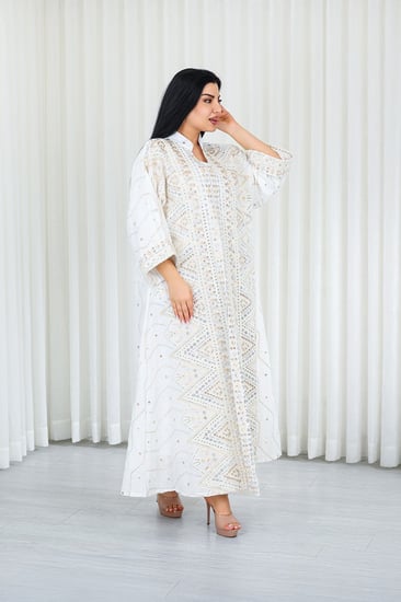 جلابية قماش بطول يصل للكاحل بأكمام واسعة متوسطة الطول وياقة صغيرة مزينة بالترتر اللامع وبالتطريزات على كامل القماش