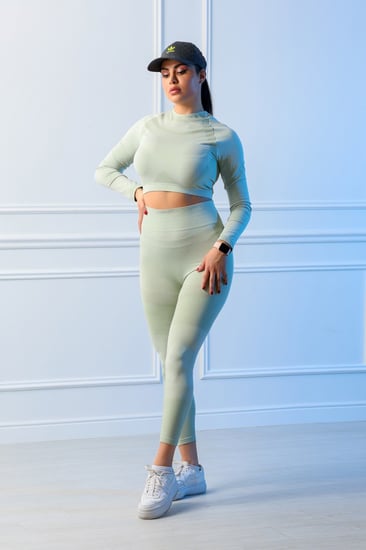 طقم رياضي نسائي مكون من توب قصير بأكمام طويلة وياقة دائرية وبنطال ضيق