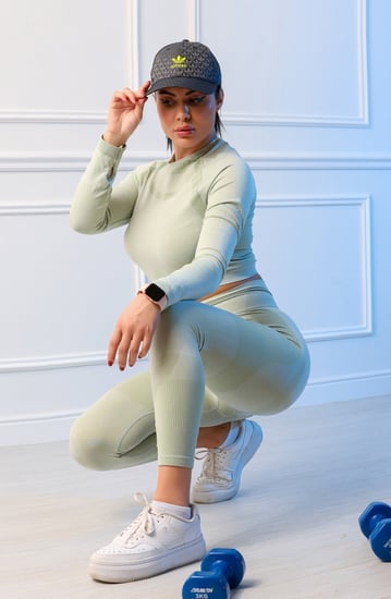 طقم رياضي نسائي مكون من توب قصير بأكمام طويلة وياقة دائرية وبنطال ضيق