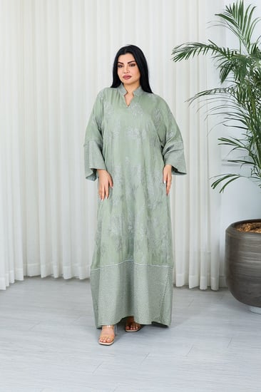 جلابية قماش بطول يصل للكاحل بنهايات أكمام واسعة وياقة صغيرة مزينة بالتطريزات والترتر على كامل القماش الأمامي