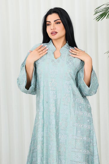 جلابية قماش بطول يصل للكاحل بأكمام واسعة مطوية متوسطة الطول وياقة صغيرة مزينة بالتطريزات على كامل القماش