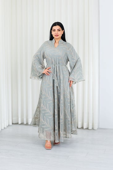 جلابية قماش بطول يصل للكاحل بطبقتين داخلية ملساء وخارجية شيفون مزودة بحزام خصر رفيع مزينة بزخارف مشجرة على طول الجلابية الخارجي ومنتصف الظهر