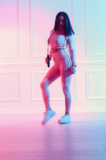 طقم رياضي نسائي مكون من توب قصير بأكمام طويلة وياقة دائرية وبنطال ضيق