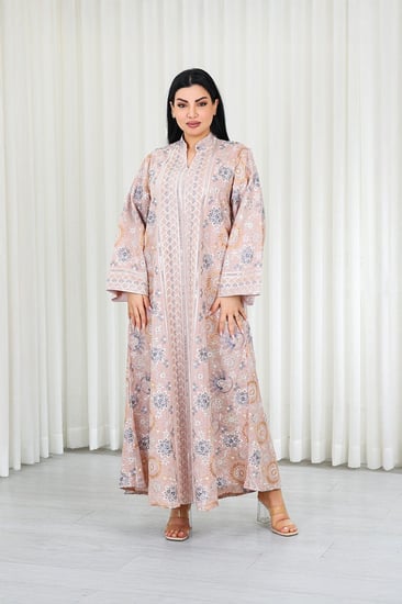 جلابية قماش بطول يصل للكاحل بأكمام واسعة متوسطة الطول وياقة صغيرة مزينة بالتطريزات موردة بشكل دائري على كامل القماش