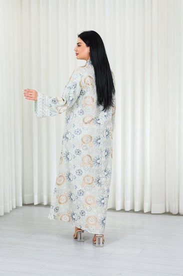 جلابية قماش بطول يصل للكاحل بأكمام واسعة متوسطة الطول وياقة صغيرة مزينة بالتطريزات موردة بشكل دائري على كامل القماش