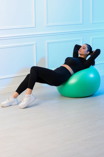 طقم رياضي نسائي مكون من توب قصير بأكمام طويلة وياقة دائرية وبنطال ضيق