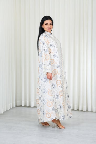 جلابية قماش بطول يصل للكاحل بأكمام واسعة متوسطة الطول وياقة صغيرة مزينة بالتطريزات موردة بشكل دائري على كامل القماش