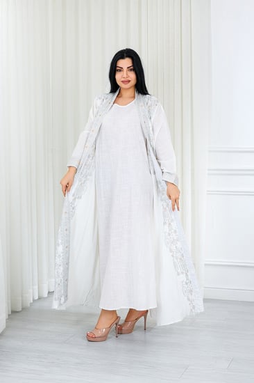 جلابية قماش بطول يصل للكاحل مكونة من قطعة سادة وقطعة مزينة بالترتر اللامع على أطراف الأكمام وعلى طول الجلابية الخارجي ومنتصف الظهر