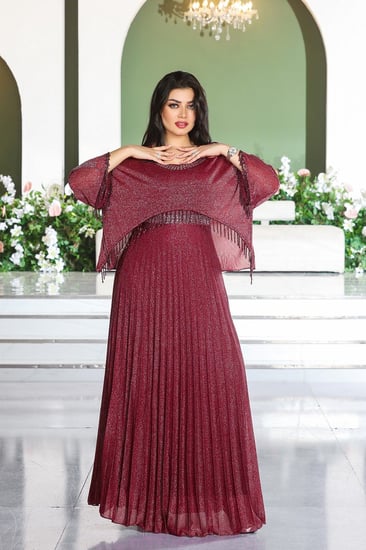 فستان سهرة طويل ياقة مدورة وأكمام مزينة بالترتر بنهايات مزينة بشباشيل وتنورة بكسرات