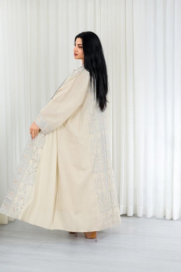 جلابية قماش بطول يصل للكاحل مكونة من قطعة سادة وقطعة مزينة بالترتر اللامع على أطراف الأكمام وعلى طول الجلابية الخارجي ومنتصف الظهر