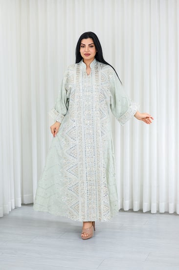 جلابية قماش بطول يصل للكاحل بأكمام واسعة متوسطة الطول وياقة صغيرة مزينة بالترتر اللامع وبالتطريزات على كامل القماش