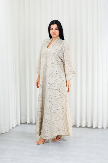 جلابية قماش بطول يصل للكاحل بياقة قصيرة مزينة بالترتر اللامع من الأمام والظهر بلا تطريز