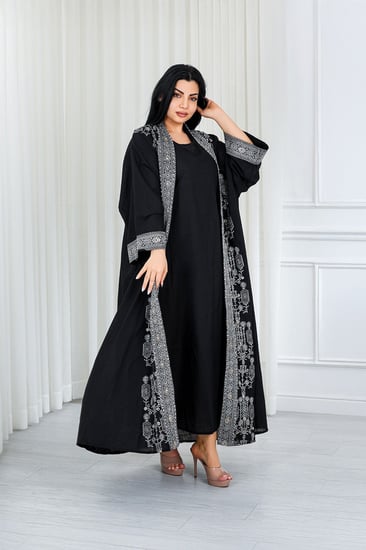 جلابية قماش بطول يصل للكاحل مكونة من قطعة سادة وقطعة مزينة بالترتر اللامع على أطراف الأكمام وعلى طول الجلابية الخارجي ومنتصف الظهر