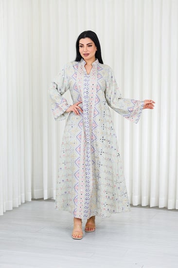 جلابية قماش بطول يصل للكاحل بأكمام بنهايات واسعة وياقة مزينة بالترتر وبالتطريزات البارزة على كامل القماش