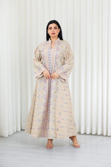 جلابية قماش بطول يصل للكاحل بأكمام بنهايات واسعة وياقة مزينة بالترتر وبالتطريزات البارزة على كامل القماش